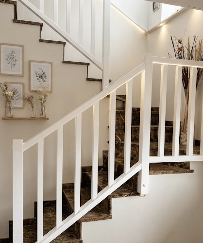 Escalera de obra revestida con barandilla clásica